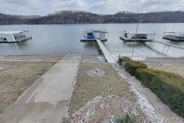 view of dock featuring a water view and a wooded view