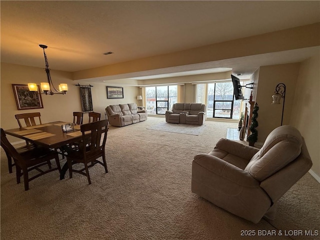 carpeted dining room with a chandelier and visible vents