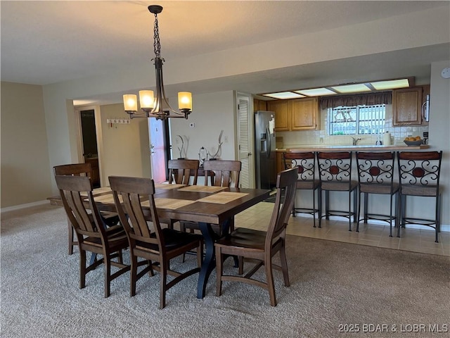 85 La Jolla Dr Unit 352-2A, Lake Ozark, MO 65049 - dining room featuring a chandelier, baseboards, and light colored carpet