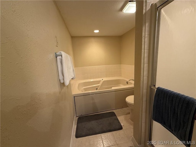 85 La Jolla Dr Unit 352-2A, Lake Ozark, MO 65049 - bathroom featuring a textured wall, a whirlpool tub, toilet, and tile patterned flooring