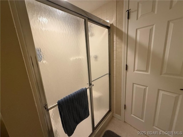 bathroom with a shower with door