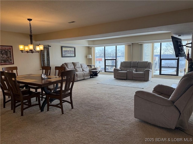 carpeted dining area with an inviting chandelier and visible vents