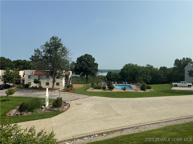 85 La Jolla Dr Unit 352-2A, Lake Ozark, MO 65049 - surrounding community featuring a pool, curved driveway, and a lawn