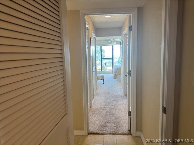 85 La Jolla Dr Unit 352-2A, Lake Ozark, MO 65049 - corridor with light carpet, baseboards, and light tile patterned floors