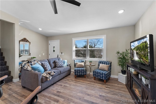 living room featuring stairs, recessed lighting, wood finished floors, and baseboards