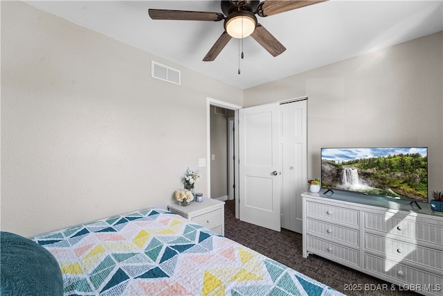 bedroom featuring visible vents, dark carpet, and a ceiling fan