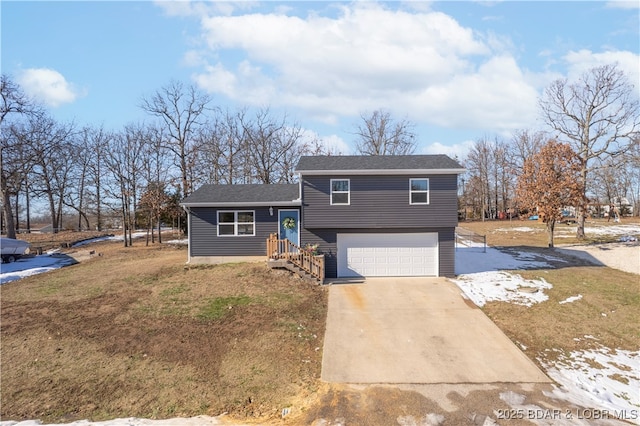 tri-level home featuring a front yard, concrete driveway, and an attached garage