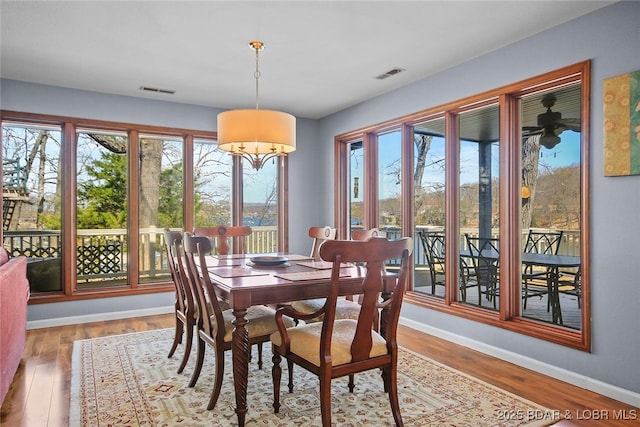 dining space with visible vents, baseboards, and wood finished floors