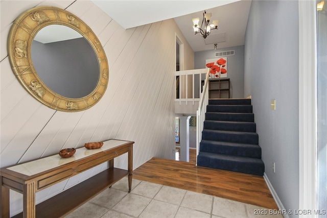 interior space featuring baseboards, tile patterned flooring, visible vents, and an inviting chandelier