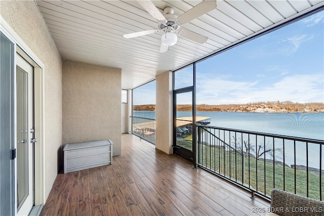 interior space with a water view and ceiling fan