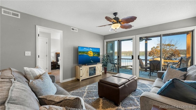 living room featuring a ceiling fan, wood finished floors, a textured ceiling, and baseboards