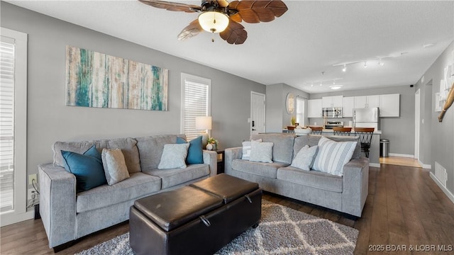 living room featuring ceiling fan, dark wood-style flooring, and baseboards