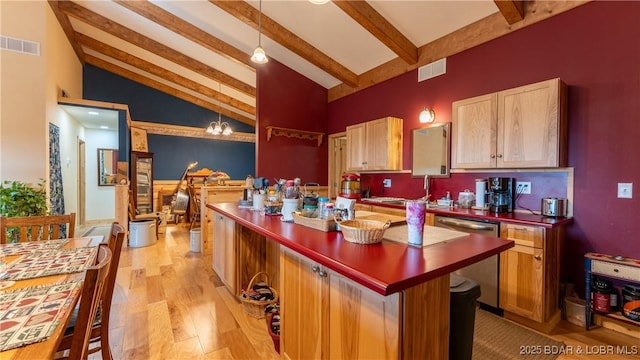 kitchen featuring dishwasher, hanging light fixtures, dark countertops, and visible vents