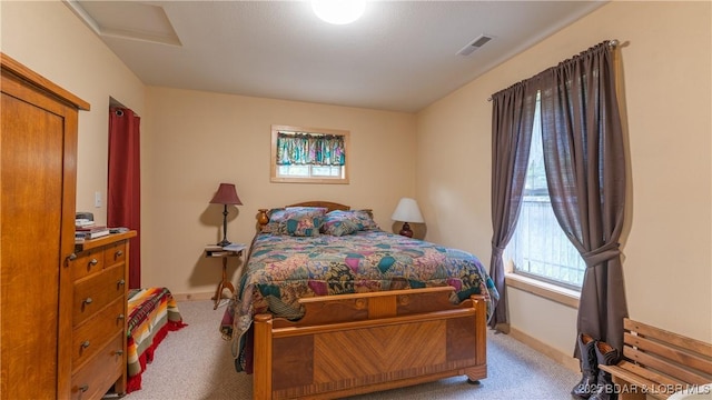 bedroom with attic access, visible vents, light carpet, and baseboards