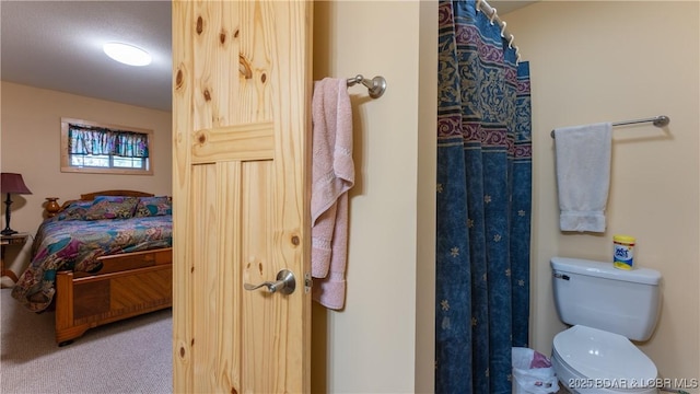 ensuite bathroom featuring a shower with shower curtain, ensuite bath, and toilet