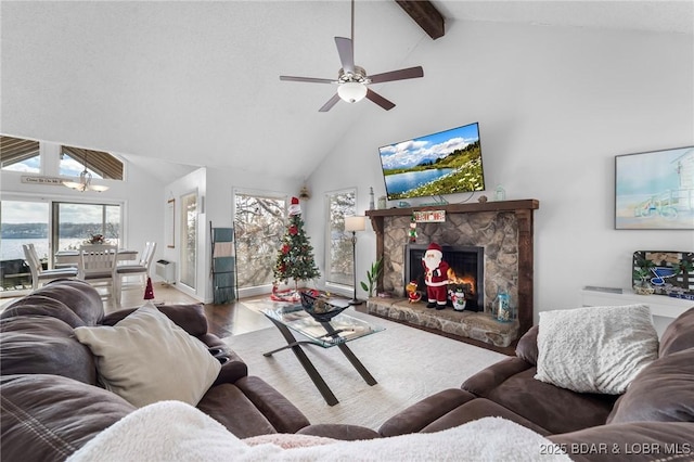 living area with a ceiling fan, beamed ceiling, wood finished floors, a fireplace, and high vaulted ceiling