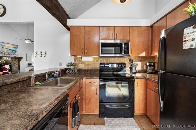 kitchen with dark countertops, black appliances, lofted ceiling with beams, and a sink