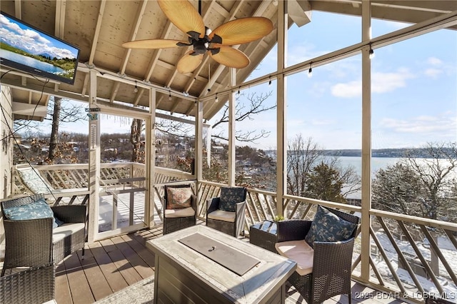 sunroom featuring lofted ceiling, a water view, and ceiling fan