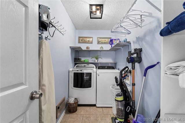 laundry room with laundry area, light tile patterned floors, visible vents, independent washer and dryer, and a textured ceiling