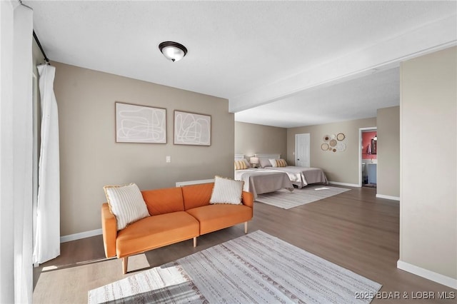 bedroom with baseboards and dark wood-type flooring