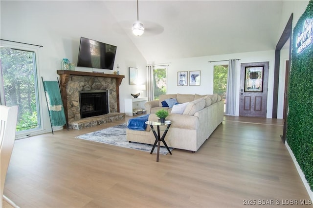 392 Hopetown Dr, Osage Beach, MO 65065 - living area featuring wood finished floors, a ceiling fan, a stone fireplace, and high vaulted ceiling