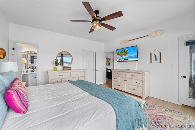 bedroom with light wood-style floors, ceiling fan, and a sink