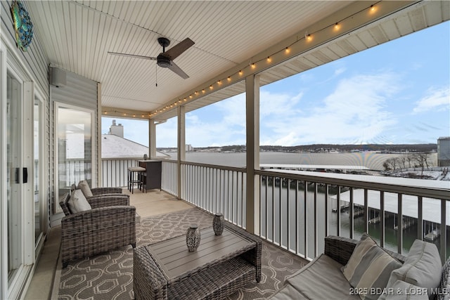 wooden deck featuring a water view and ceiling fan