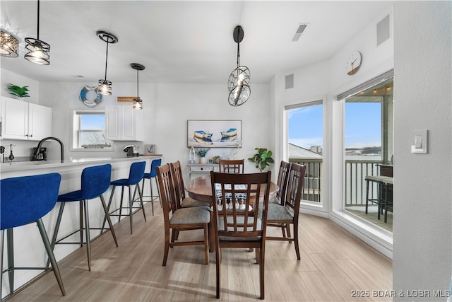 dining space featuring visible vents and light wood finished floors