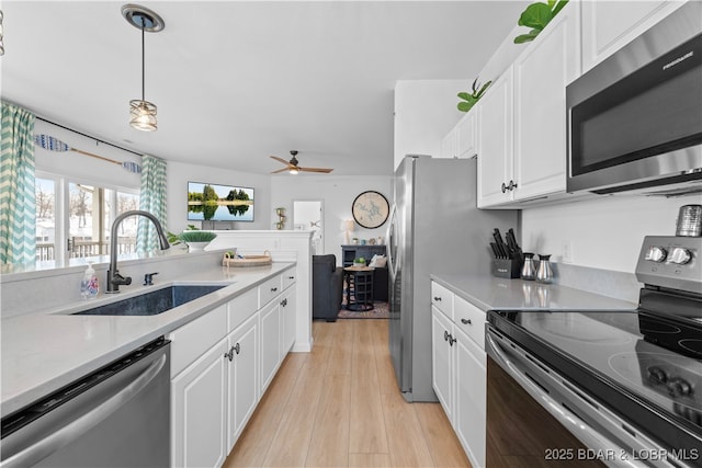 kitchen with white cabinetry, appliances with stainless steel finishes, light countertops, and a sink