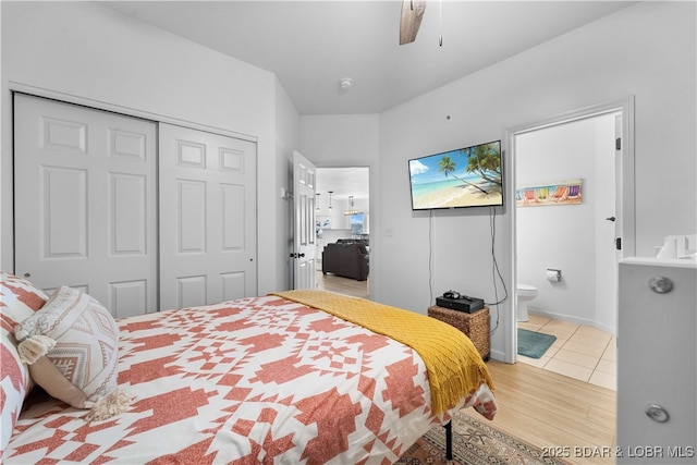 bedroom featuring light tile patterned floors, ensuite bath, ceiling fan, and a closet