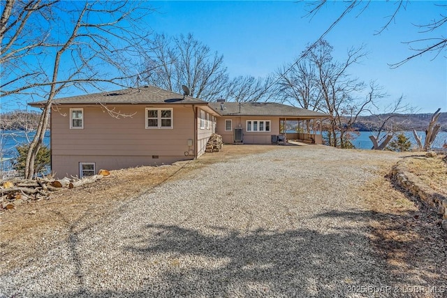 back of house with gravel driveway