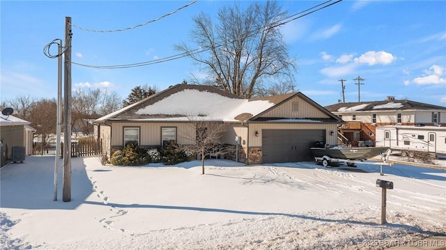 view of front of property featuring central AC, an attached garage, and fence