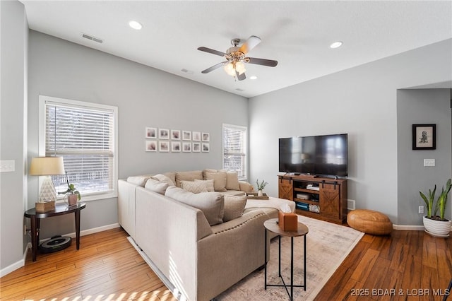 living area with light wood-type flooring, plenty of natural light, visible vents, and baseboards