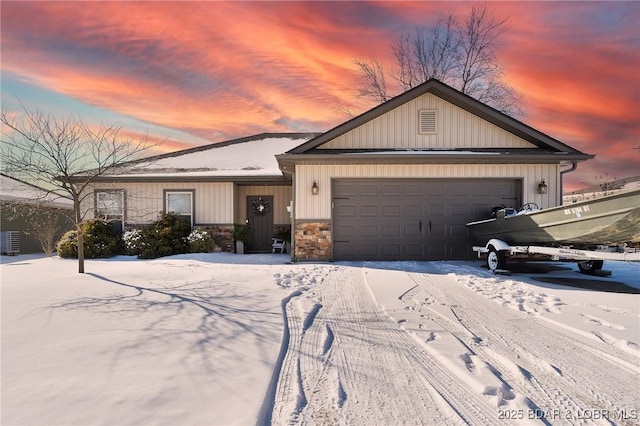 view of front of house featuring a garage, stone siding, and board and batten siding