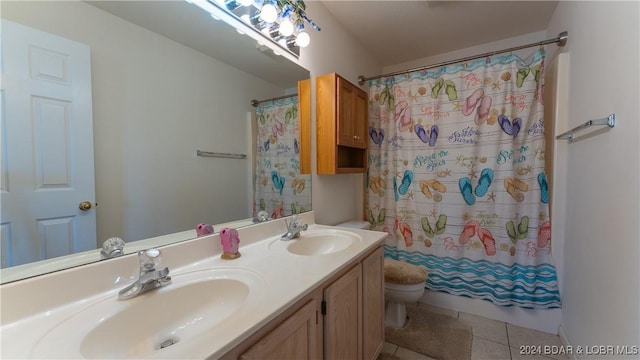 bathroom with tile patterned flooring, a sink, toilet, and double vanity