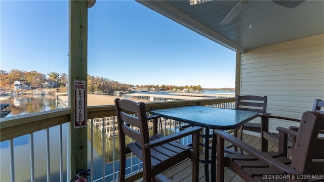 balcony with a water view and a ceiling fan