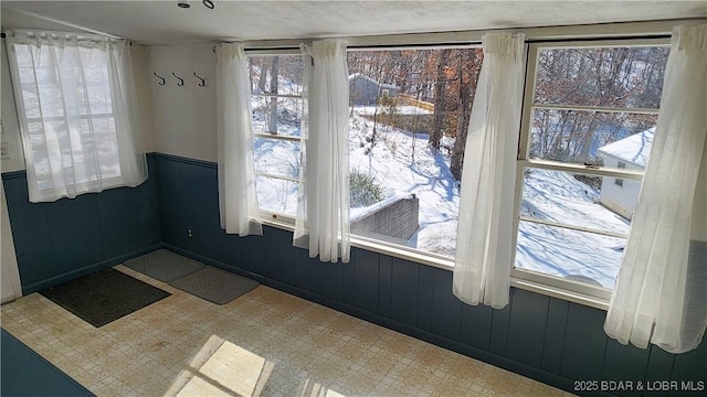 empty room featuring a wainscoted wall and tile patterned floors