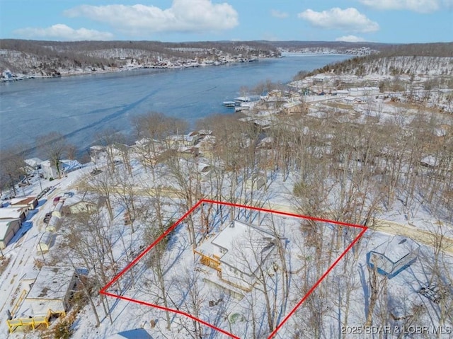 snowy aerial view featuring a water view