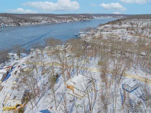 snowy aerial view featuring a water view