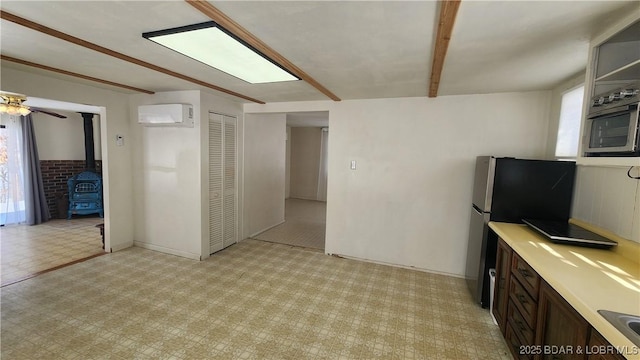 interior space featuring a wood stove, light floors, light countertops, and dark brown cabinets