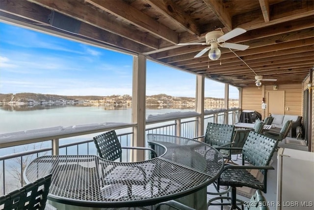 snow covered deck with a water view and a ceiling fan