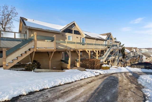 view of front facade with stairs, a wooden deck, and a residential view