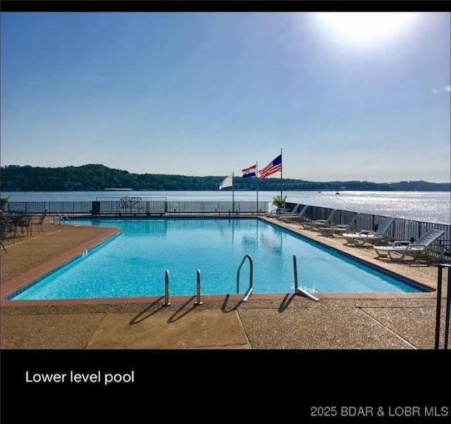 pool featuring a water view and fence