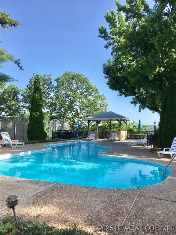 community pool featuring a gazebo, a patio area, and fence