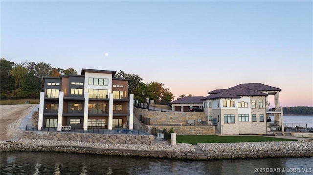 rear view of house with a water view and a balcony