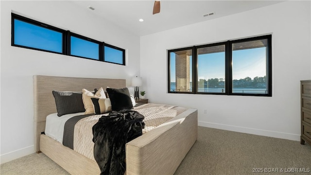 bedroom with light carpet, a ceiling fan, visible vents, and baseboards