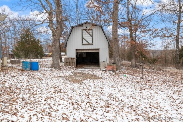 snow covered structure featuring an outdoor structure and a barn