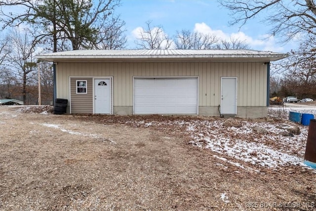 snow covered garage with a detached garage