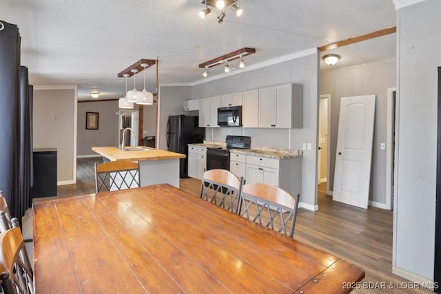 dining room with light wood-type flooring, baseboards, and crown molding