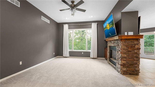 unfurnished living room featuring visible vents, a stone fireplace, and baseboards